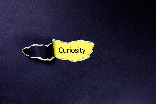 curiosity word under torn paper - Photo, Image