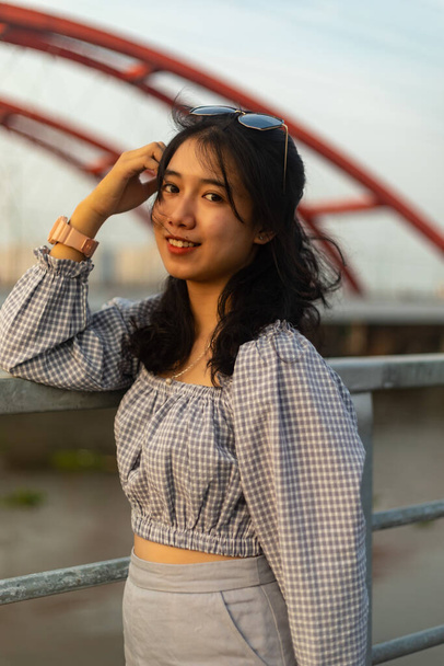 A vertical shot of an attractive Asian woman posing on the bridge - Φωτογραφία, εικόνα