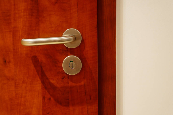 A closeup of a shiny metallic doorknob under the lights - Zdjęcie, obraz