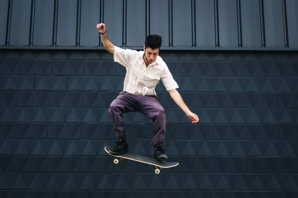 A young Caucasian man doing tricks with a skateboard at a skate park - Foto, imagen