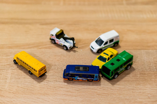 POZNAN, POLAND - Oct 28, 2018: Mix of toy cars laying on a wooden floor including Matchbox and Siku brand. Horizontal high angle view. - Photo, Image