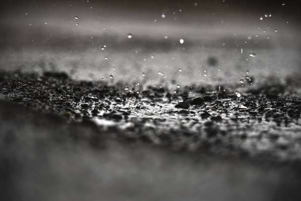 Βρόχινο νερό πέφτει στο νερό της βροχής. δυνατή βροχή που πέφτει και νερό που πιτσιλάει χρήσιμο φόντο. - Φωτογραφία, εικόνα