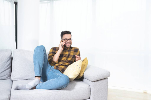Счастливый человек разговаривает по мобильному телефону дома - Фото, изображение