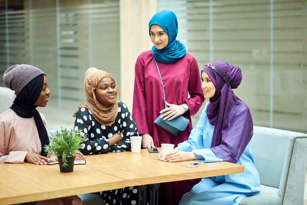 Muslim young women of diverse ethnicity talking about new book of famous author - Fotó, kép