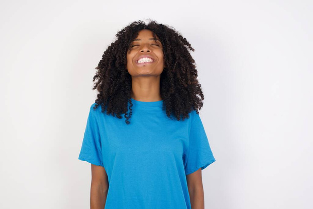 Young african woman with curly hair wearing casual blue shirt standing against white  background very happy and excited about new plans. - Φωτογραφία, εικόνα