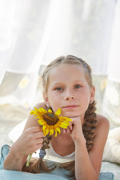 Little girl in  white chiffon tent with sunflower. Childhood, tenderness, beauty - Photo, Image