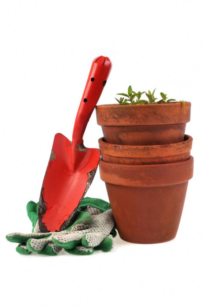 Pot de fleurs avec outil de jardin et gants gros plan sur fond blanc  - Photo, image