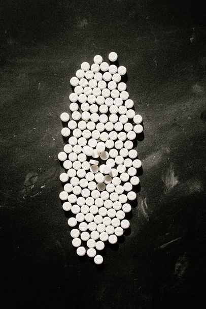 Group of white pills on a black table - Fotó, kép