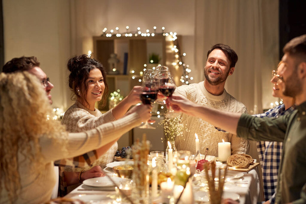 happy friends drinking red wine at christmas party - Zdjęcie, obraz