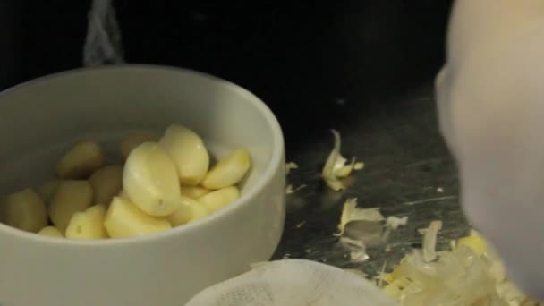 Cook kuorinta valkosipuli ravintolassa keittiö - Materiaali, video