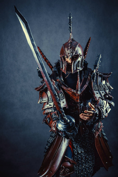 Krachtige ridder in het harnas met het zwaard. Donkere achtergrond. - Foto, afbeelding