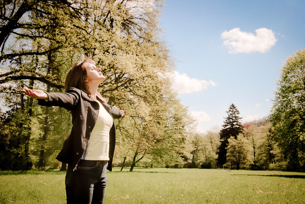 Woman enjoys sun in spring time outdoors - Photo, Image