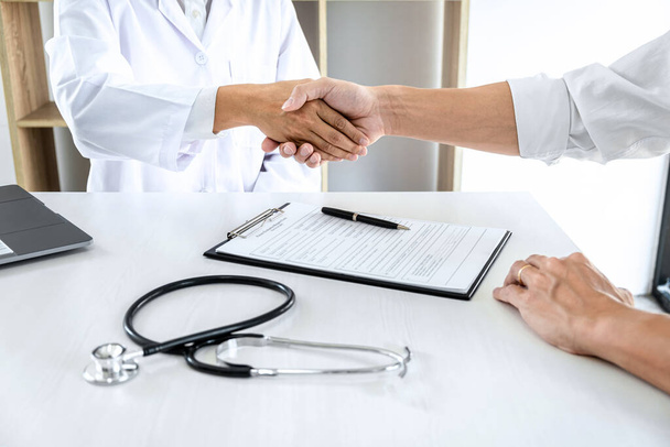 Medicine and health care concept, Professional Male doctor in white coat handshake with patient after successful recommend treatment methods. - Valokuva, kuva