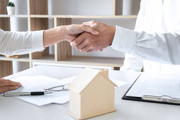 Real estate agent and customers shaking hands together celebrating finished contract after signing about home insurance and investment loan, handshake and successful deal. - Fotó, kép