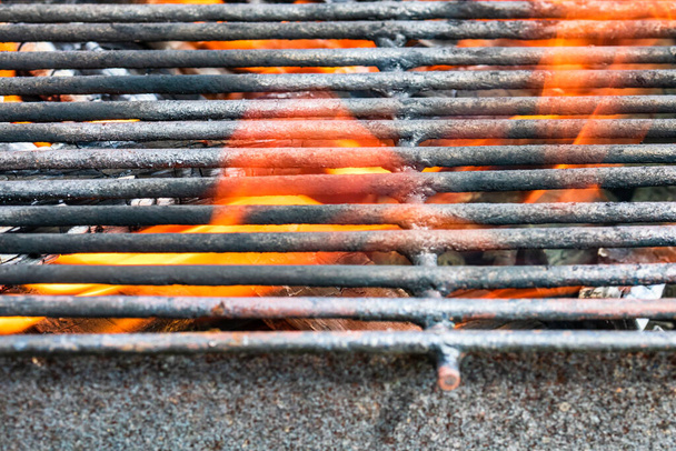Parrilla de barbacoa de carbón caliente vacía con fuego ardiente con llama y humo. Carbón caliente hecho de madera muy calentada - Foto, Imagen