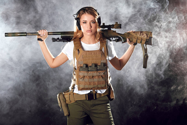 Army woman with gun over smoky darkness - Fotografie, Obrázek