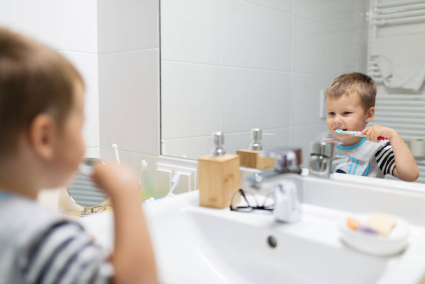 Adorable child brushing his teeth in the bathroom - 写真・画像