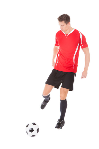 Young Male Soccer Player Kicking Football - Fotó, kép