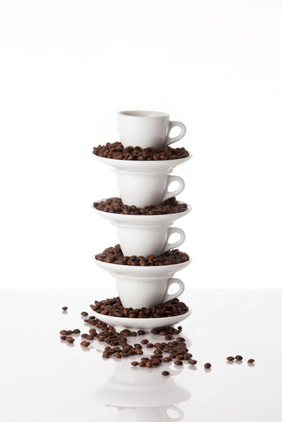 Hromada čtyř šálků kávy plných pražených kávových zrn - Fotografie, Obrázek