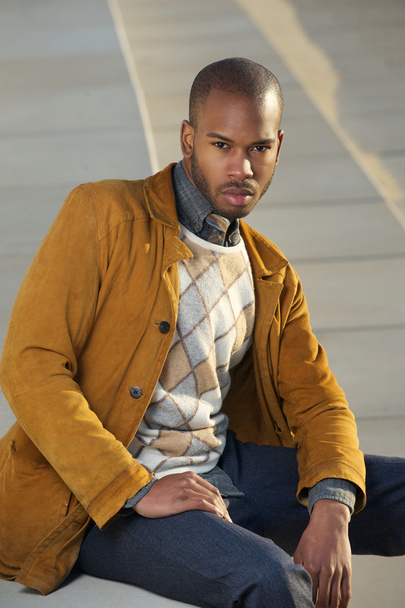 Young black man sitting outdoors with serious expression - Photo, Image