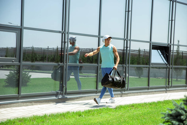 Sports man against modern glassed building, airport in megapolis - Fotó, kép