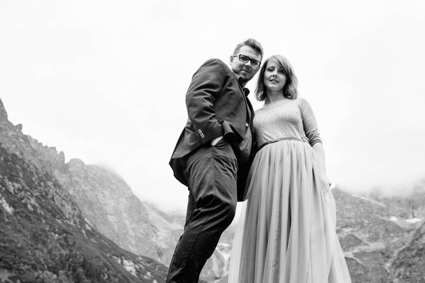 jovem casal em um passeio perto do lago cercado pelas montanhas dos Cárpatos
 - Foto, Imagem