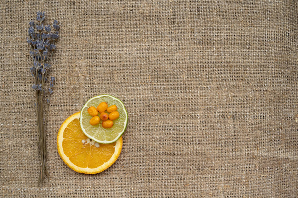 blauw lavendel boeket limoen oranje plak en duindoorn op zak  - Foto, afbeelding