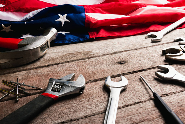 USA Labor day concept, Top view flat lay of different kinds wrenches with American flag on wood table. First Monday in September, creation of labor movement and dedicated to social of American worker - Photo, Image