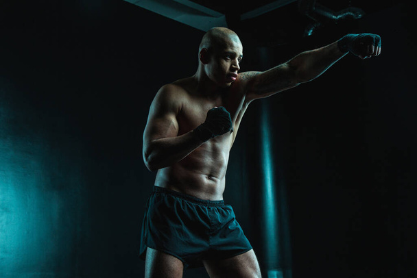 Handsome muscular man looking confident while training with boxing bandages on the hands - Fotografie, Obrázek