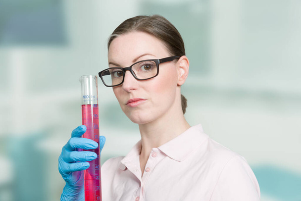 scienziata donna con una provetta contenente un coloratissimo su liuid - Foto, immagini