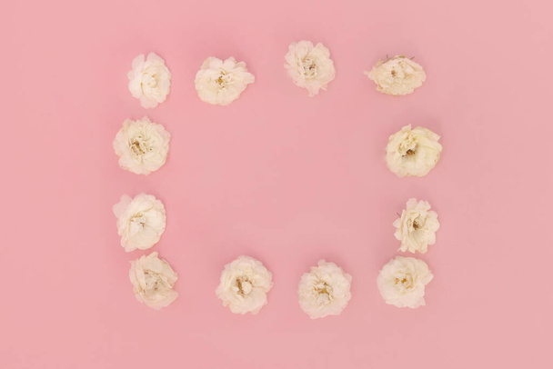 frame of white little roses on a pink background. The concept of beauty and love. Romantic mood. Valentine day. Copy of the text space. - Foto, Imagem