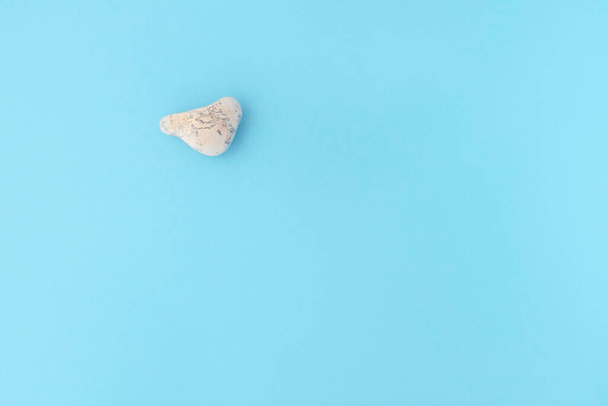 sea stone in the form of a heart on a blue background. Vacation concept - Фото, изображение