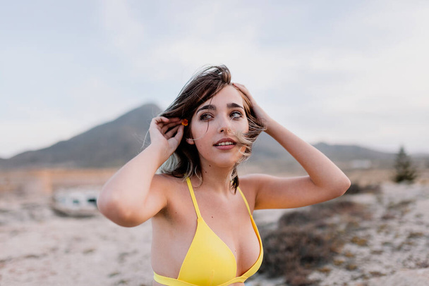 Woman in the beach wearing yellow swimsuit - Фото, изображение