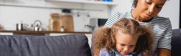 horizontal image of african american mother and daughter sitting together in kitchen - Photo, Image