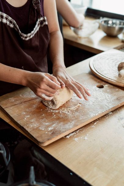 Nő cukrász gyúrás kenyér tészta a munkaasztalon a konyhában. Liszttel és vajjal főzni. Hogyan készítsünk kenyértésztát kézzel. Főzési eljárás. - Fotó, kép