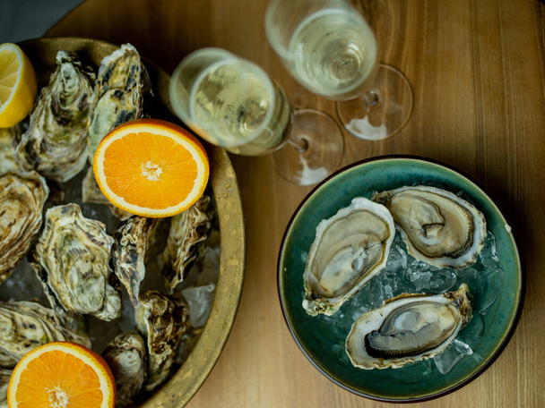 Oysters with champagne glasses on table - Fotó, kép