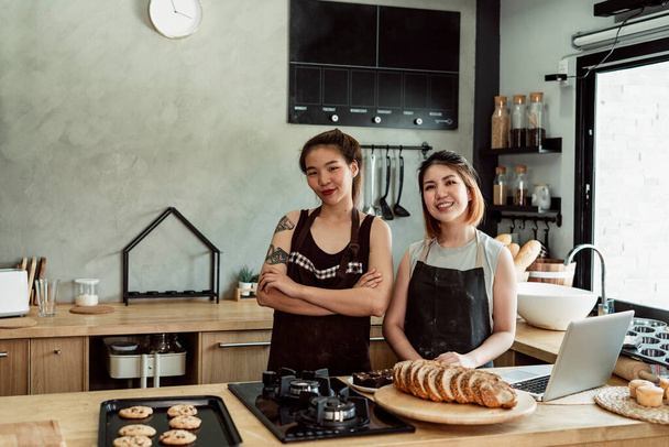 Due allegro giovane asiatico panificio chef in il cucina dentro panetteria negozio. - Foto, immagini