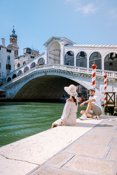 Wenecja Włochy para mężczyzn i kobiet na wycieczkę po Wenecji, mężczyzn i kobiet na nabrzeżu patrząc na słynny most Rialto w Wenecji Włochy - Zdjęcie, obraz