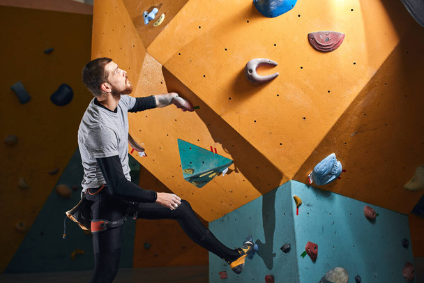 Male physically challenged boulderer staring thoughtfully at climbing wal - Foto, immagini