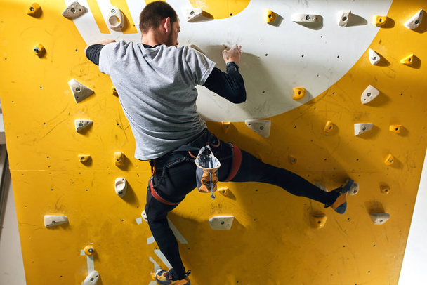 Physically challenged climber training hard, climbing up at yellow rock wall - 写真・画像