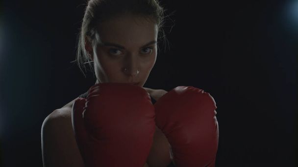 Spor kadın, kardiyo eğitiminde kırmızı boks eldivenleriyle yumruk atıyor. Kadın boksör - Fotoğraf, Görsel