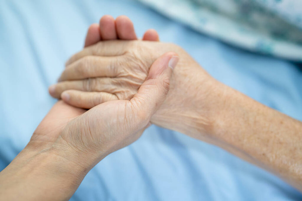 Doctor holding touching hands Asian senior or elderly old lady woman patient with love, care, helping, encourage and empathy at nursing hospital ward, healthy strong medical concept - Photo, Image