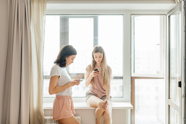 Two beautiful girls using their smart phones - Photo, Image