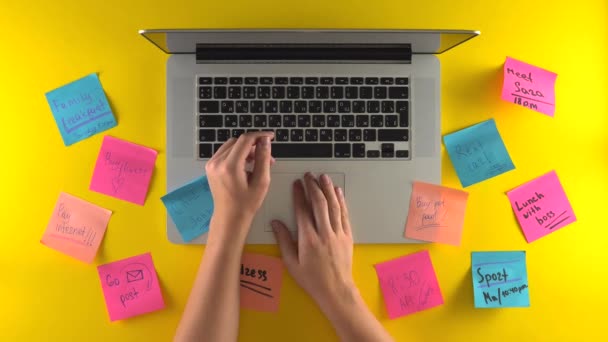 Usando las manos de escritura portátil, colóquelo en el lugar de trabajo, recuerde pegatinas en el escritorio - Metraje, vídeo