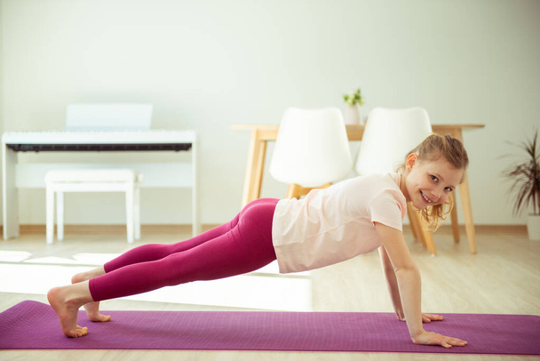 Happy pretty teen child girl making yoga at home  - Foto, afbeelding