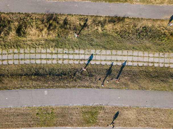 Aerial drone view. Mowing grass on the side of the road with petrol trimmers. - Foto, Bild
