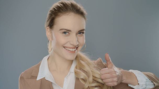 Business woman showing thumbs up on grey background. Happy businesswoman - Photo, Image