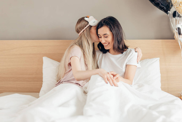beautiful girl whispering in sisters ear, sharing secrets - Fotografie, Obrázek