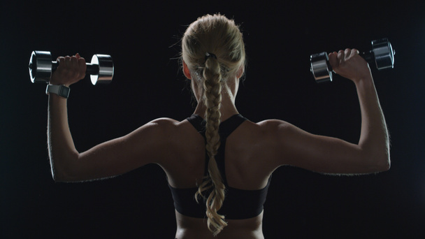 Sport woman training with dumbbells in slow motion. Fitness girl exercising - Foto, Imagen