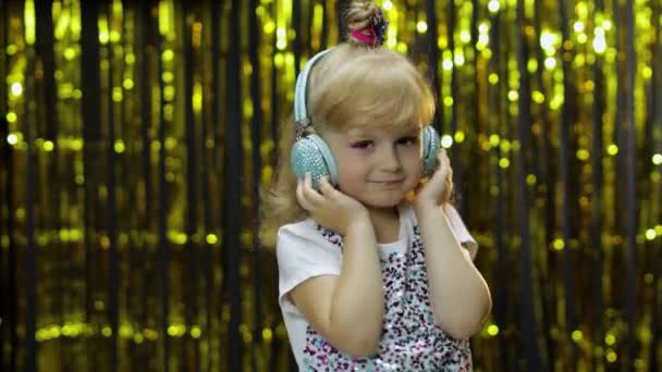 Child dances, listens music on headphones. Little kid girl dancing, having hun, relaxing, enjoying - Footage, Video